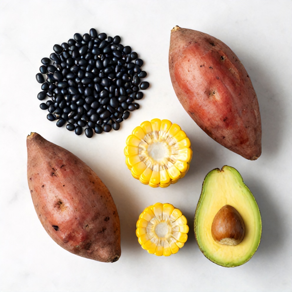 Black beans, sweet potatoes, corn, avocado, and other ingredients in a flat lay
