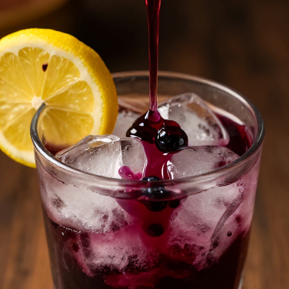 Blueberry syrup poured over ice in a glass